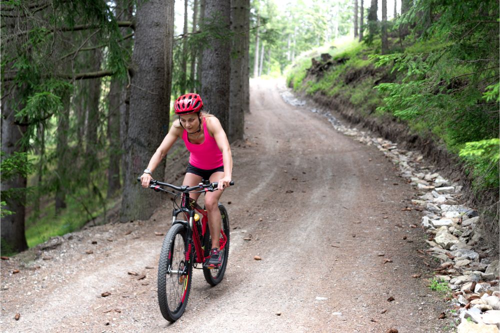 the sportswoman rides on a mountain hardtail bike on the forest road